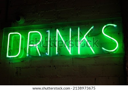 drinks neon light green over white brick wall