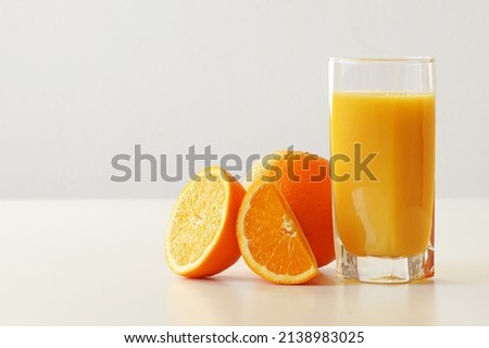 A good breakfast is orange juice. Pictured is a glass of freshly squeezed orange juice, a fresh and juicy orange, a half and a quarter. An excellent start to the day, a boost of energy, vivacity and v