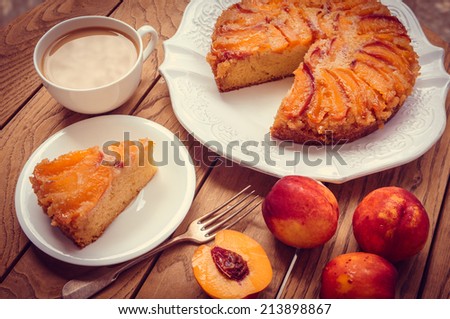 Delicious homemade nectarine cake on wooden background. Toned picture