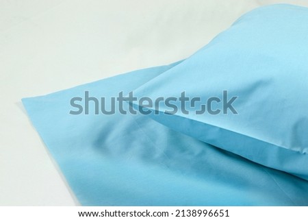 Corner of a soft pillow in a new colored cotton fiber pillowcase. Satin  material to protect and decorate the pillow. Bed linen for home and hotels Royalty-Free Stock Photo #2138996651