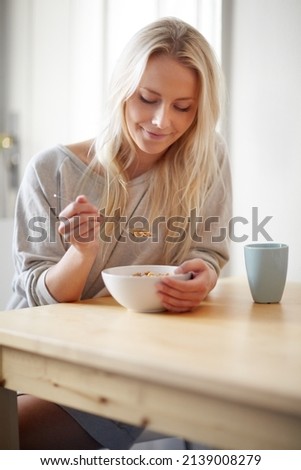 A great way to start the day. A gorgeous young woman enjoying her breakfast with a cup of coffee.