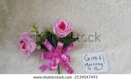 Good morning text and roses on soft fluffy fabric background. Selective focus.