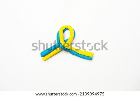 blue-yellow ribbon with plasticine as a symbol of Ukraine on a white background, War in Ukraine
