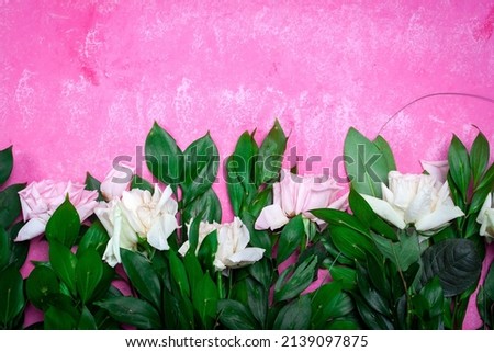 Small white flowers on a toned on gentle soft blue and pink background outdoors close-up macro . Spring summer border template floral background. Light air delicate artistic image, free space.