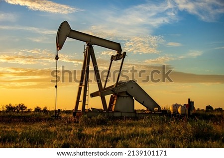 Active oil rig at working at sunrise or sunset in the Texas Panhandle. A great photo for resources education and needs. Royalty-Free Stock Photo #2139101171