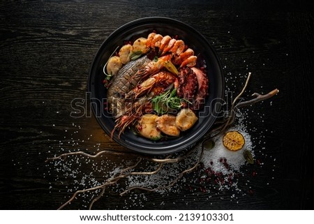 Mixed Seafood Contain Blue Crabs, Mussels, Big Shrimps, Calamari Squids and Grilled Barracuda Fish Garlic with Lemon on Dish Royalty-Free Stock Photo #2139103301
