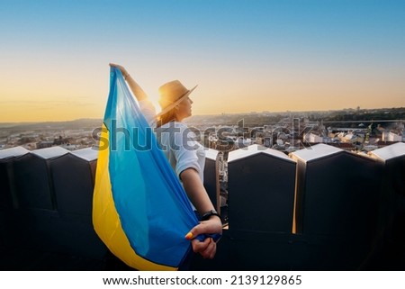 A woman stands with the national Ukrainian flag and waving it praying for peace at sunset in Lviv.
A symbol of the Ukrainian people, independence and strength. Pray for Ukraine.