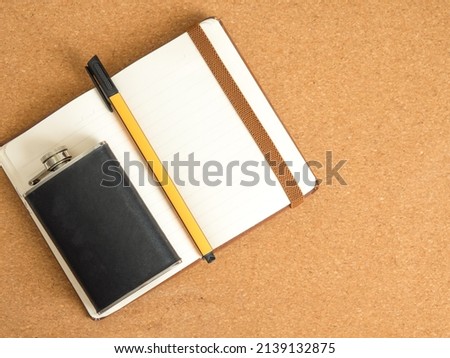 workspace with pen, notepad and whiskey flask with space for text