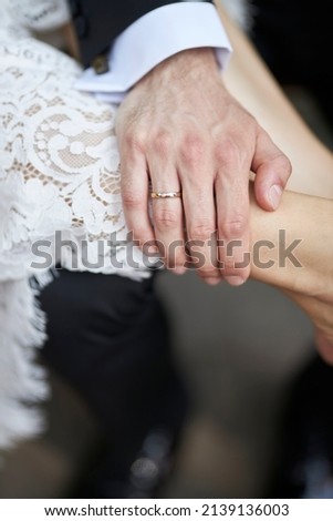 the groom's hand on the bride's leg. The groom put his hand on the bride's leg. groom's hand close up