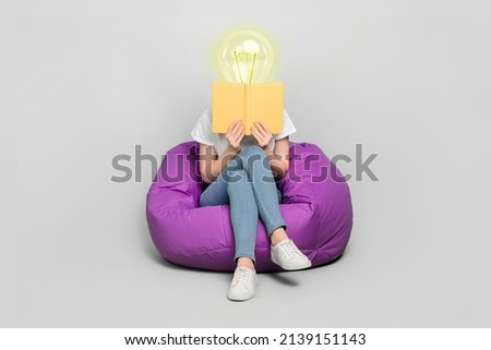 Female body of model with bright electric bulb instead head read book sit bean bag isolated on grey color background modern design learn concept Royalty-Free Stock Photo #2139151143