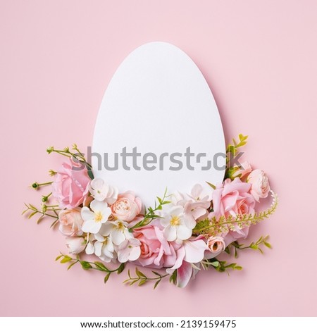 Easter banner template with egg shape empty copy space surrounded with fresh flowers on pastel pink background. Creative Easter concept. Traditional holiday greeting card or shopping poster. Flat lay.