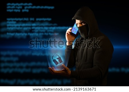 Scammer telephoning his victims while holding a broken padlock in his hand symbolizing breached security. Concept of vishing Royalty-Free Stock Photo #2139163671