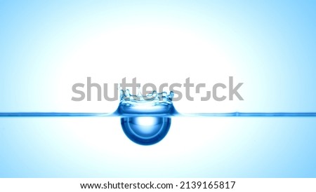 Blue drop falls down on blue transparent liquid creating a crown on it's surface | Abstract skin moisturizing cosmetics mixing concept Royalty-Free Stock Photo #2139165817