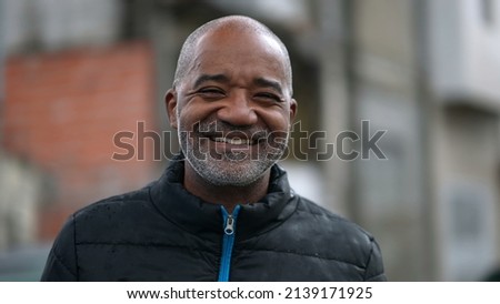 A happy senior black man portrait face smiling at camera standing outside in street Royalty-Free Stock Photo #2139171925