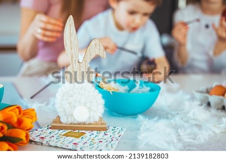 Easter. Happy family mother father and children are preparing for the holiday home with eggs. Young couple coloring animal eggs for Easter with their children