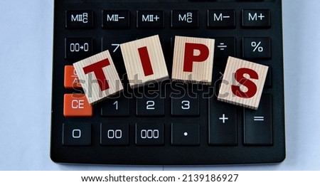TIPS - word on wooden cubes on the background of a calculator. Business and finance concept