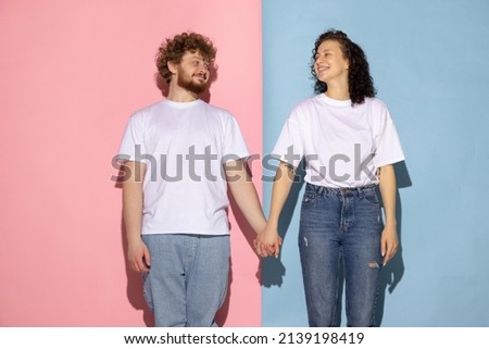 Care, support. Portrait of young emotive man and girl posing isolated on blue and pink trendy color background. Human emotions concept. Human emotions, youth, love and lifestyle concept