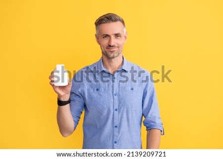 daily vitamins and supplements. male offer painkiller. smiling man hold jar with medicine pills