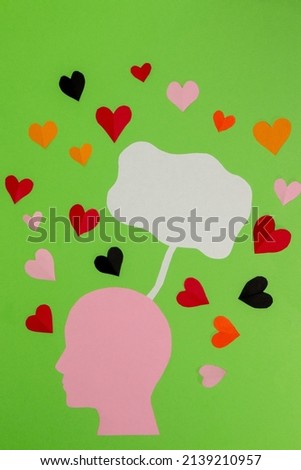 pink paper head with white bubble above as copy space and colorful hearts around, on green background, flat design, eco love concept