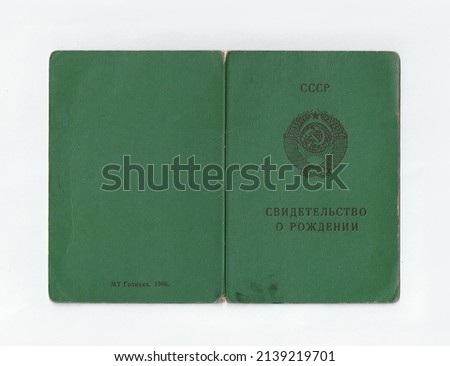 Photo of old dirty shabby green cover of birth certificate of citizen of the USSR. Translation from Russian: Birth certificate, state sign. Print date 1986. Russian document for children