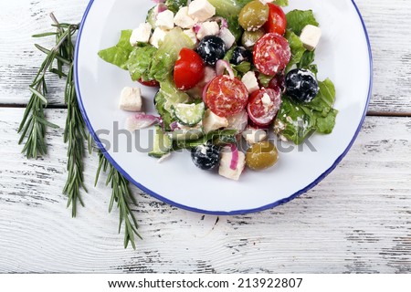 Plate of Greek salad on wooden background