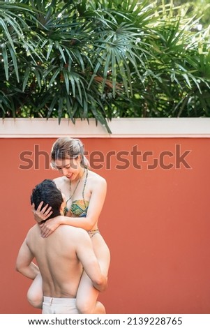 Couple in love, Man carrying woman in  swimming pool.