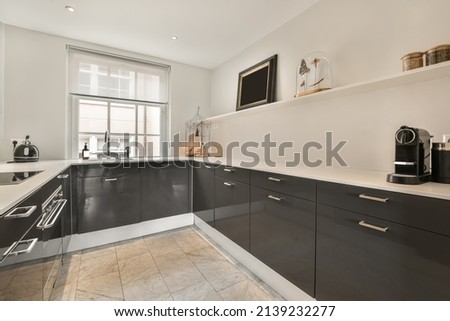 Compact kitchen with black and white furniture and necessary equipment Royalty-Free Stock Photo #2139232277