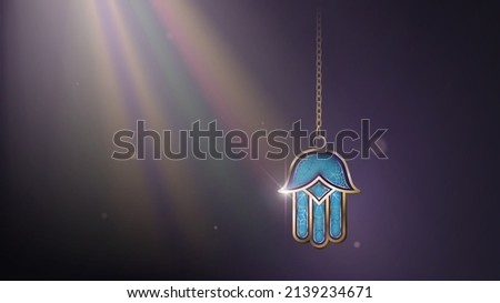 Blue and gold Hamsa (Hand of Fatima) on a chain in the rays of light, an oriental evil eye amulet Royalty-Free Stock Photo #2139234671
