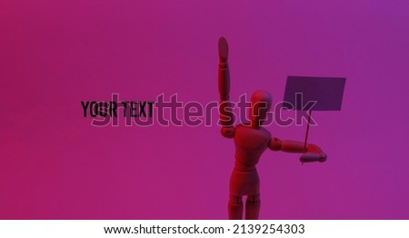 Protesting activist wooden puppet with blank banner in neon red light. Meeting. Defending your rights. Space for your text