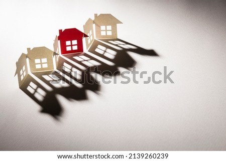 red one in line link of complete paper house in light with shadow on white texture paper background in concept of business and banking. selective focus point.