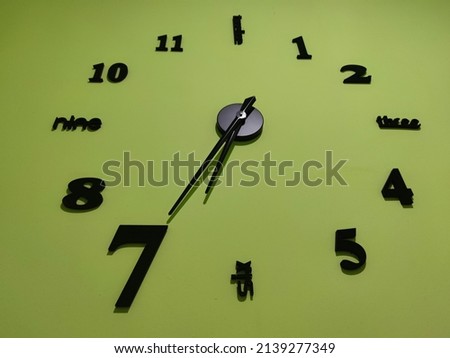 Clock showing 12 o'clock pm on a green wall
