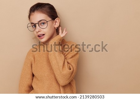 Portrait of happy smiling child girl with glasses emotions gesture hands Lifestyle unaltered