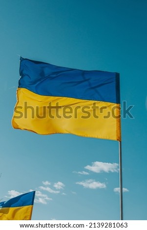 The flag of independent Ukraine develops against the background of the blue sky. Freedom, independence, peace, we are against war.