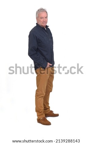 side view of a man hands on pockets and looking at camera on white background