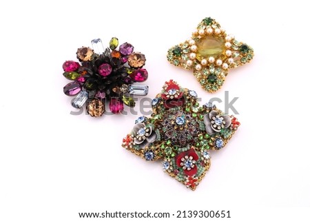 Three vintage costume jewellery brooches. Isolated on a white background.