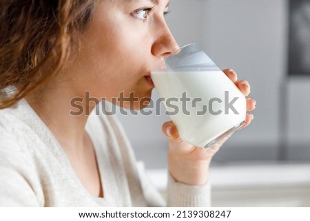 Young woman is drinking milk  Royalty-Free Stock Photo #2139308247