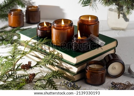 A set of different aroma candles in brown glass jars. Scented handmade candle. Soy candles are burning in a jar. Aromatherapy and relax in spa and home. Still life. Fire in brown jar Royalty-Free Stock Photo #2139330193