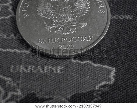 Macro-photo the obverse of russian coin on the map of Ukraine. Translation: BANK OF RUSSIA, 2022.