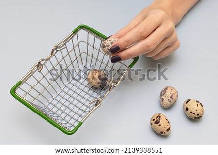 female hand puts quail eggs in a basket. High quality photo