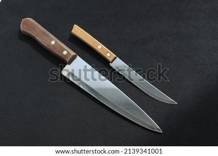 set of kitchen knives with wooden handles on a black background