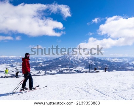 Skier with a snowy volcano (Niseko, Hokkaido, Japan) Royalty-Free Stock Photo #2139353883