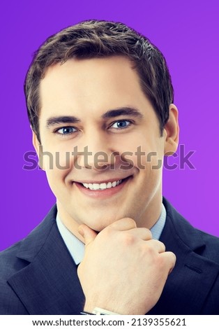 Portrait of cheerful smiling senior businessman in blue suit and tie, violet purple color background. Thinking confident middle aged business man.