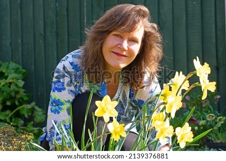Capturing a beautiful and happy lady appreciating a host of daffodils and spring sunshine in March.