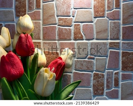 Artificial colorful tulip bouquet with classic stone wall background. Copy space in right side.