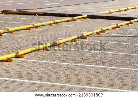 Road yellow barriers and dedicated lane markings for car parking. City construction architecture. Car parking lots at the mall. Urban space. Safety area.