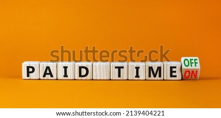 Paid time off or on symbol. Turned a wooden cube and changed words 'paid time on' to 'paid time off'. Beautiful orange background. Business and paid time off or on concept, copy space. Royalty-Free Stock Photo #2139404221