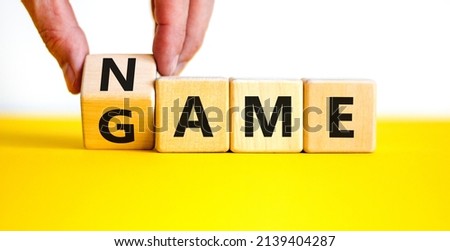 Name of the game symbol. Wooden blocks with concept words Name Game. Businessman hand. Beautiful yellow table white background. Business and name of the game concept. Copy space. Royalty-Free Stock Photo #2139404287