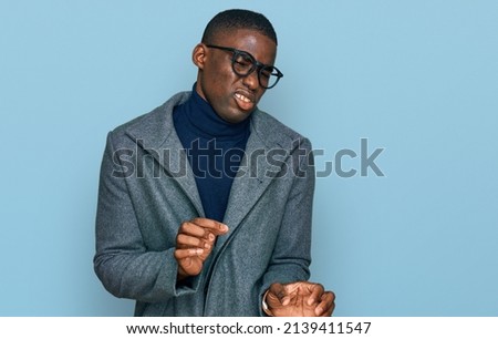 Young african american man wearing business clothes and glasses disgusted expression, displeased and fearful doing disgust face because aversion reaction. 