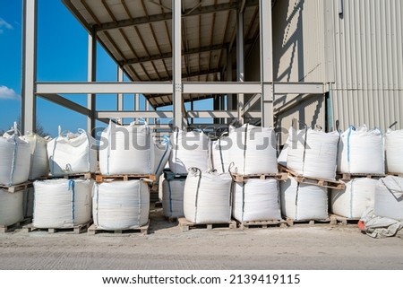 Stored bags of agriculture fertiliser seen outside a warehousing facility. Located on pallets, ready for distribution to farms. Royalty-Free Stock Photo #2139419115