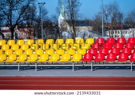 a fragment of the grandstand of an sports stadium with multi-colored seats